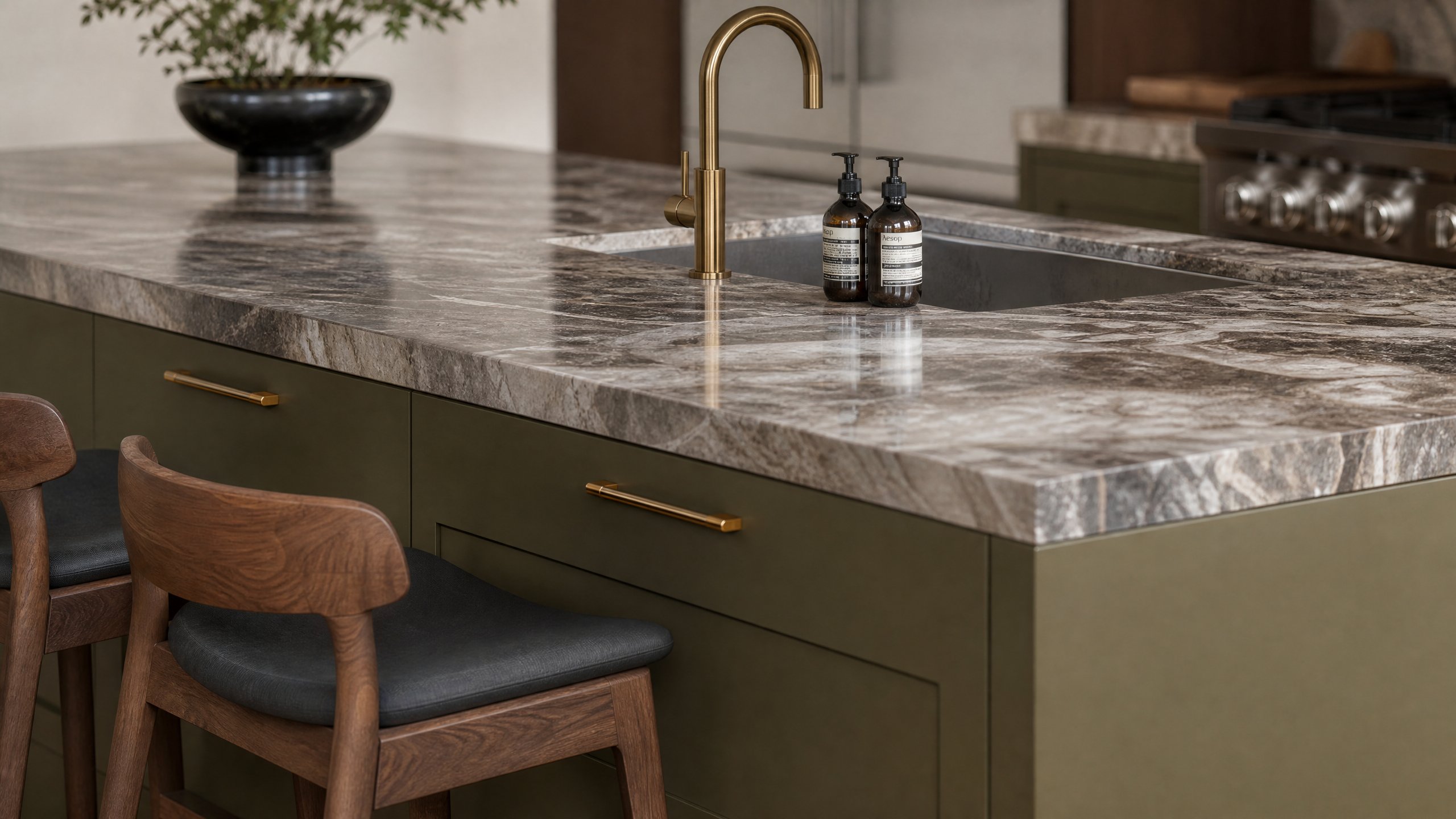 Detalle de encimera dekton negro con grifería de latón en cocina de lujo